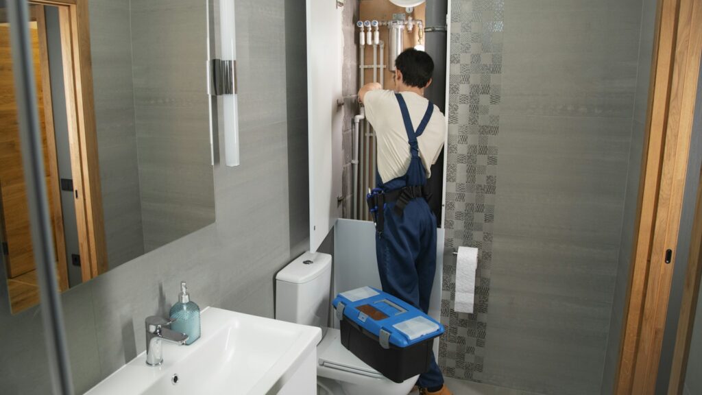 Plumber repairing a bathroom pipe for a customer who found him through Google Local Services Ads