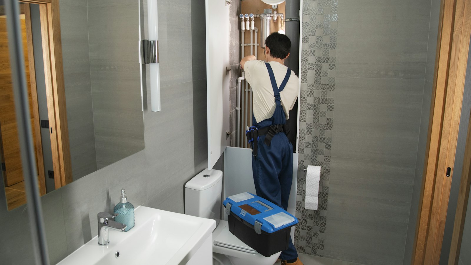 Plumber repairing a bathroom pipe for a customer who found him through Google Local Services Ads